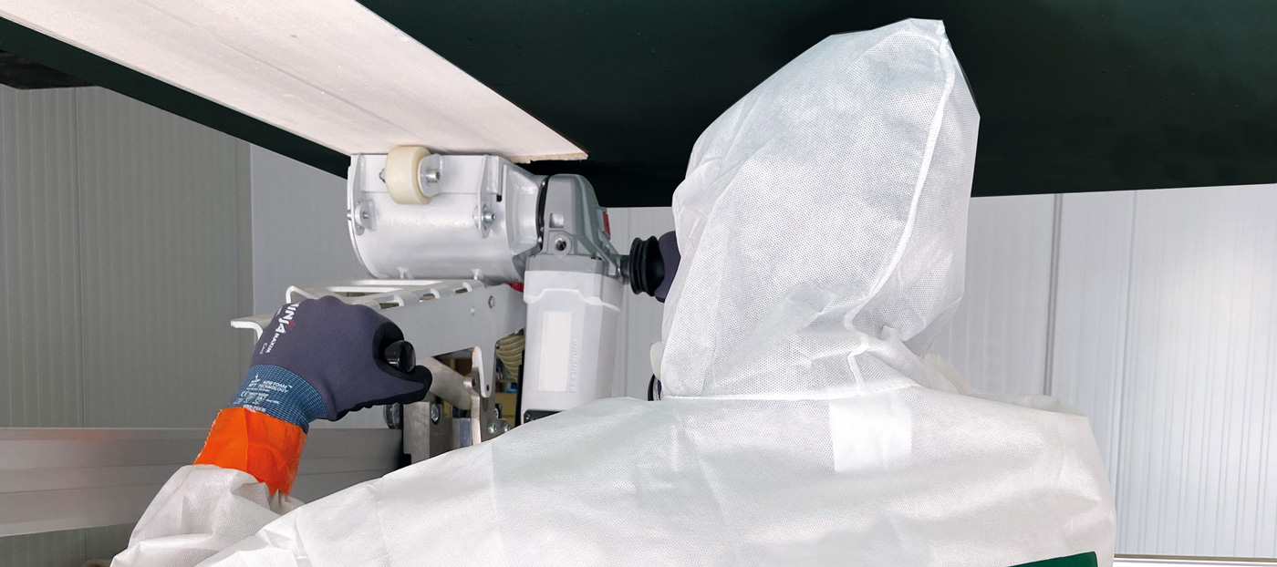 Mann mit Schutzausrüstung fräst Material von Decke – BT-Verfahren